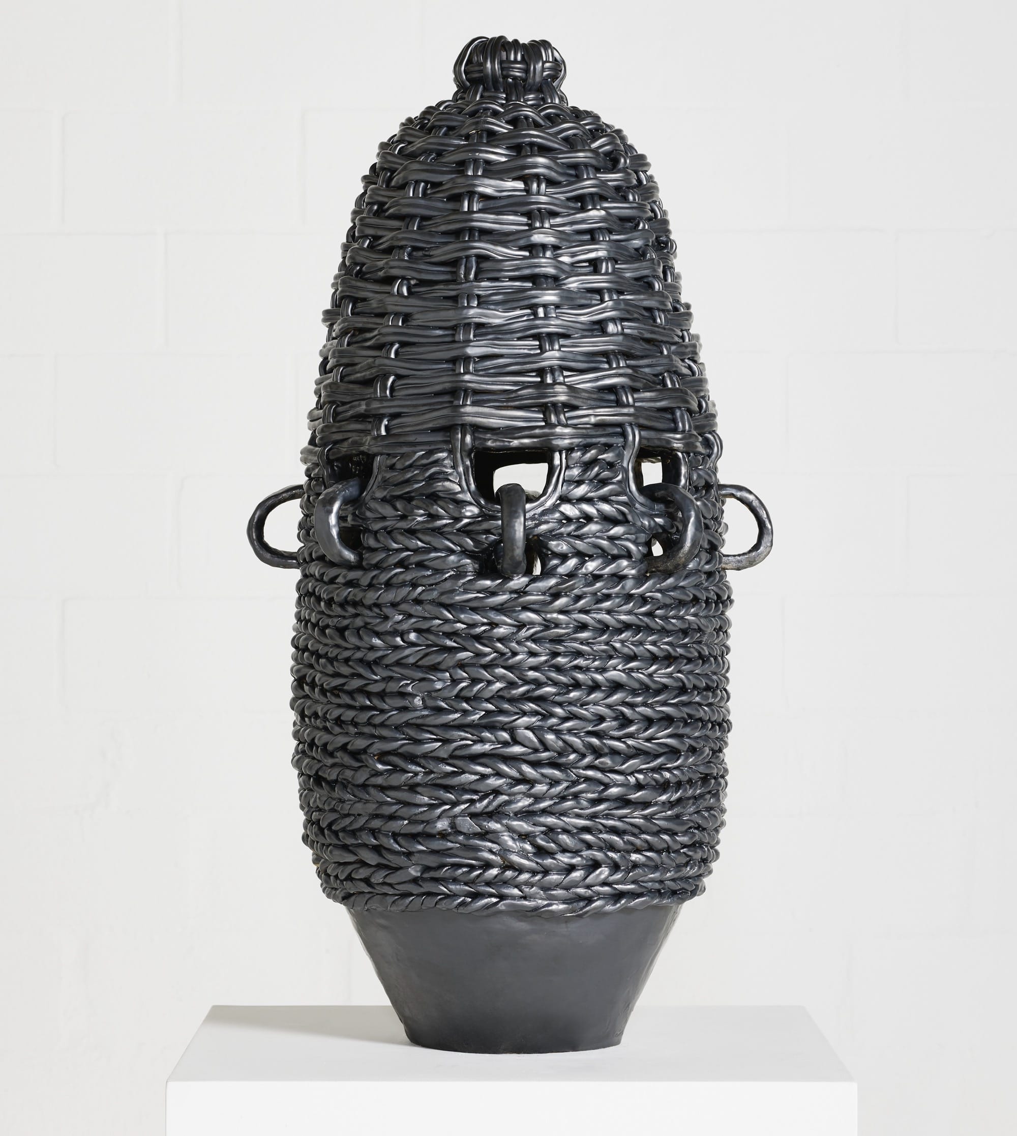 a large-scale ceramic vessel painted black, with a woven texture