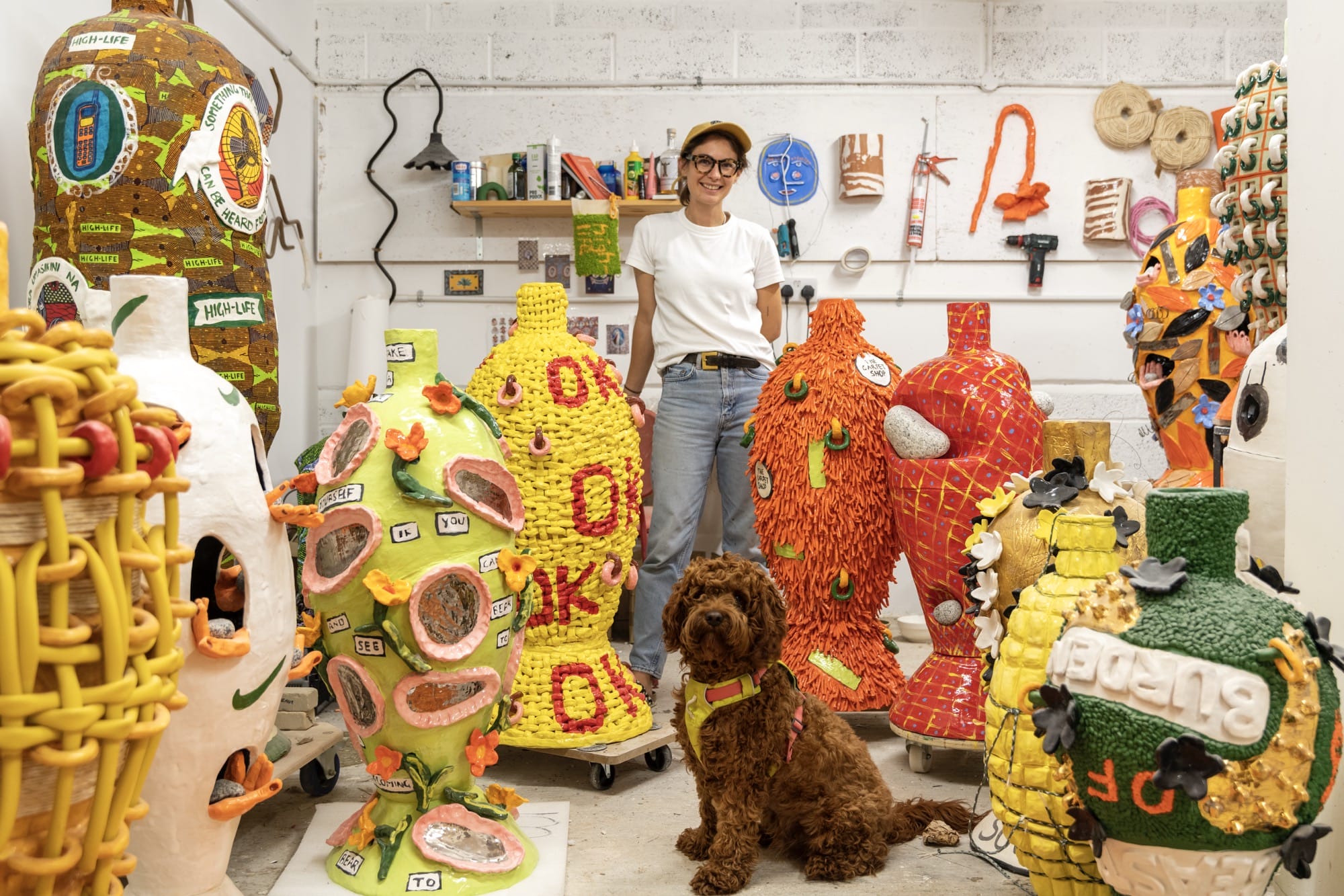 artist Xanthe Summers in her studio surrounded by numerous, large-scale ceramic vases