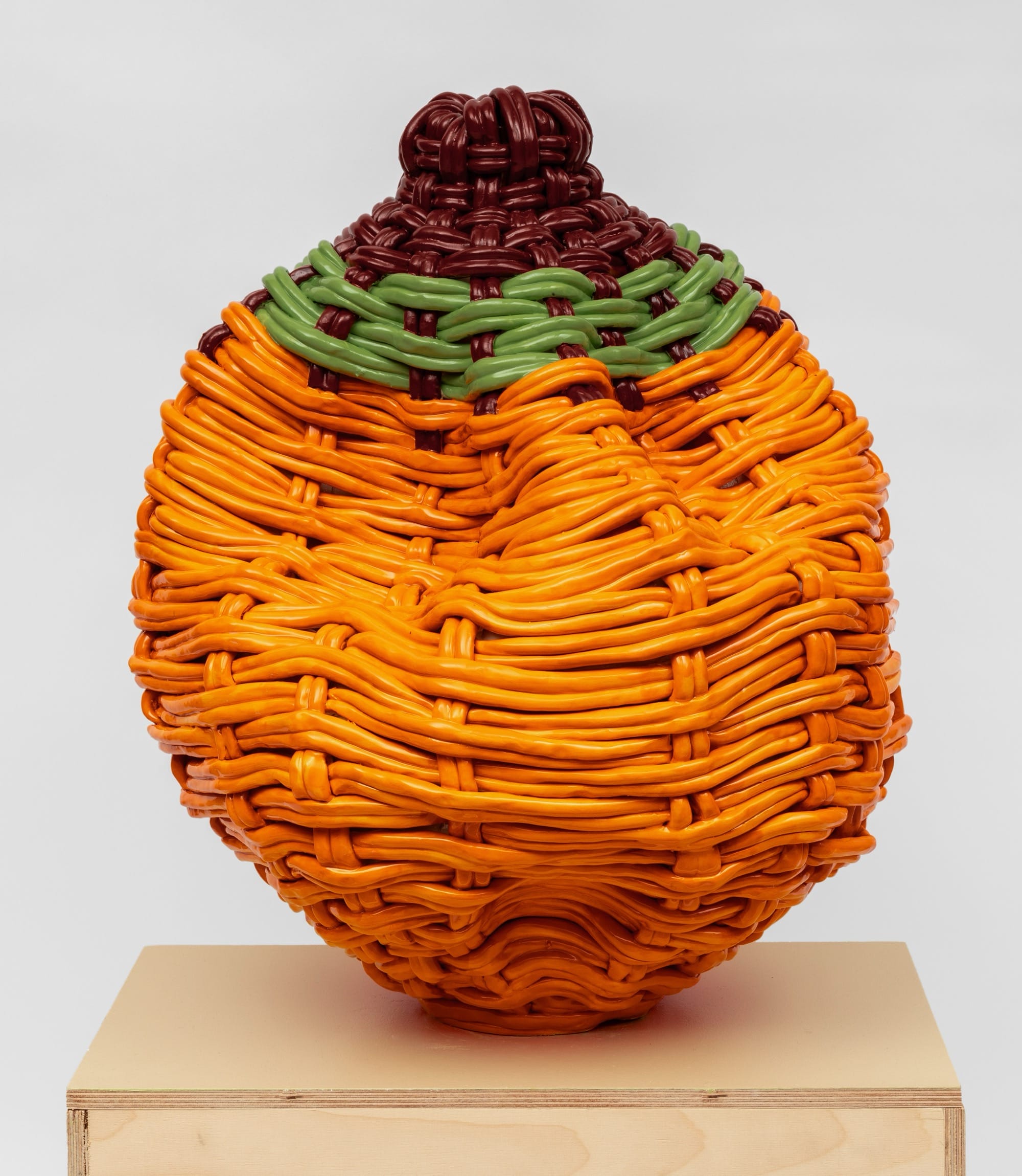 an abstract ceramic sculpture of a woven vessel that has partially crumpled at the top